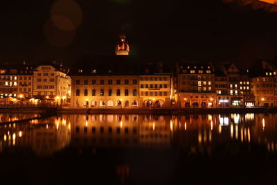 Reflection of buildings in lake at night