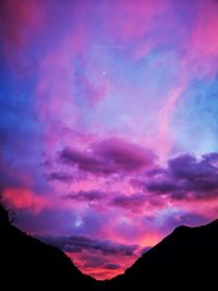 Silhouette mountain against dramatic sky during sunset