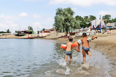 People on shore against sky