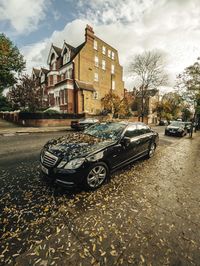 Car parked in city against sky