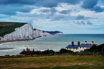 Scenic view of sea by buildings against sky