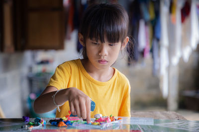 Portrait of girl playing with table