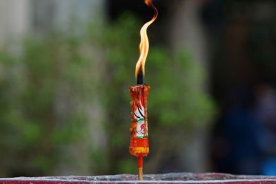 Close-up of lit candle at temple