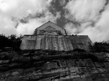 Low angle view of old ruin building against cloudy sky