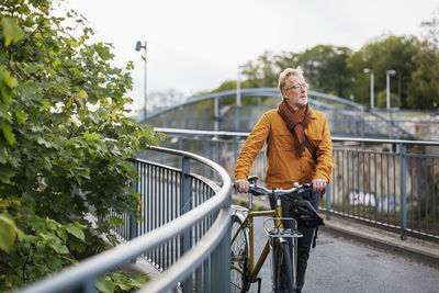 Man riding bicycle on footbridge