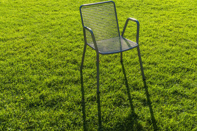 High angle view of empty chair on grassy field