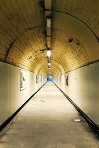 Empty corridor in illuminated tunnel