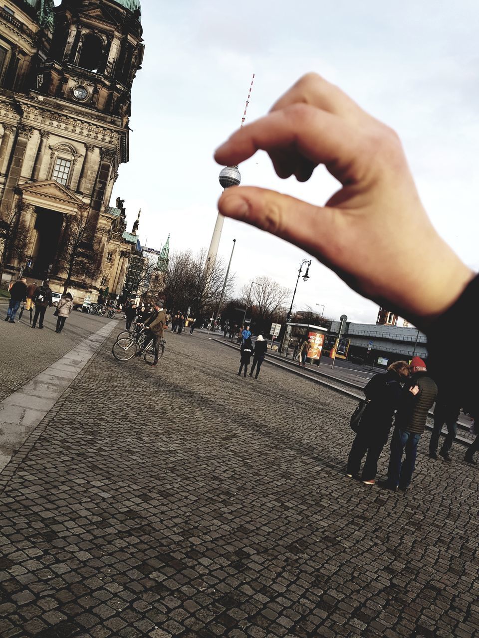 real people, human hand, architecture, men, building exterior, outdoors, sky, human body part, lifestyles, leisure activity, day, built structure, holding, women, city, people in the background, close-up, adult, people