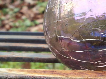 Close-up of old glass container on field