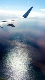 Cropped image of airplane flying over clouds