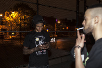 Man using mobile phone while standing at night