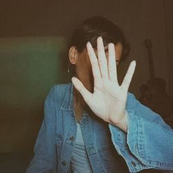 Portrait of human hand covering face