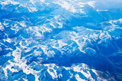 Airplane view of blue mountains covered with white snow. can be used as nature background