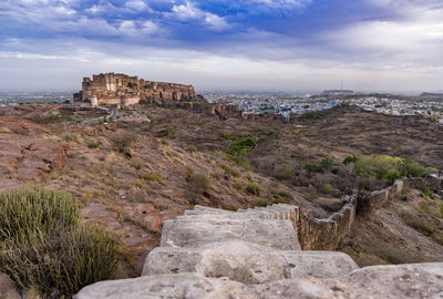 Ancient historical fort with colored city houses and dramatic cloudy sky at evening