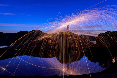 Panoramic view of illuminated mountain against sky at night