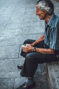 Man using mobile phone while sitting outdoors