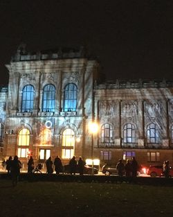 People in illuminated building at night