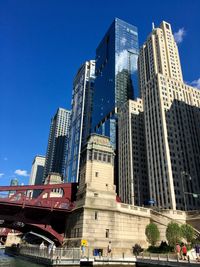 Low angle view of skyscrapers against blue sky