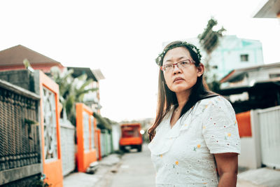 Portrait of woman standing against wall