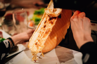 Close-up of hand holding bread on plate