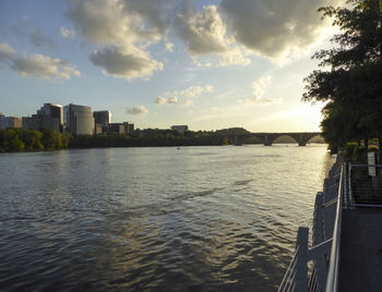 Scenic view of river by city against sky