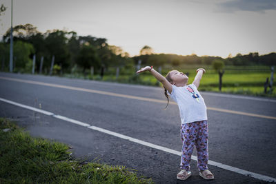 Rear view of woman standing on road