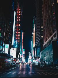 Illuminated city street and buildings at night