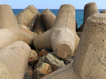 Close-up of rocks at beach against sea and sky