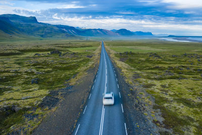 Panoramic view of road leading towards mountains against sky