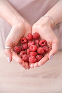 Midsection of woman holding strawberries