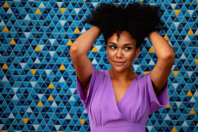 Smiling woman standing against tiled wall