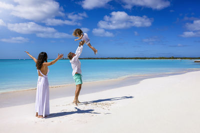 Full length of woman standing at beach against sky