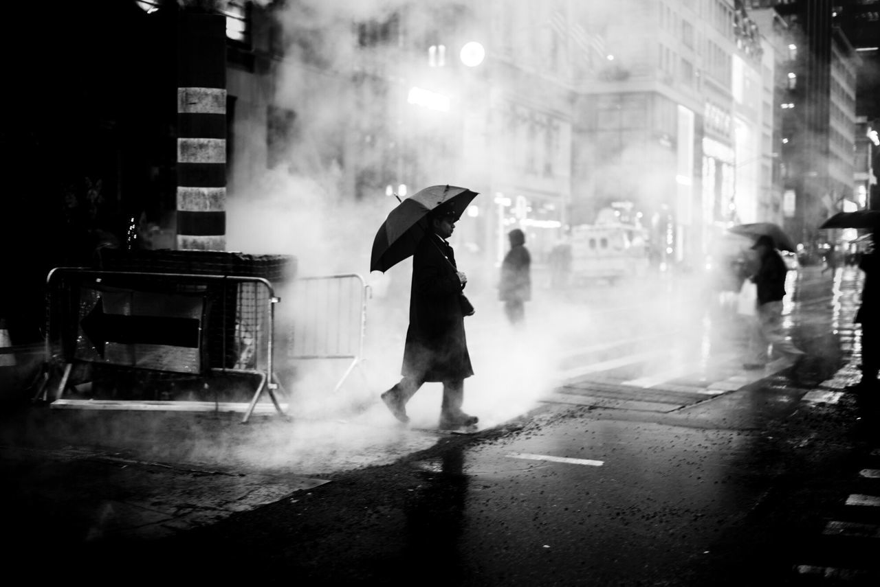 street, city, rain, wet, full length, walking, car, city street, smoke - physical structure, city life, real people, people, adult, one person, outdoors, survival, day, adults only