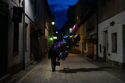 Men in illuminated city against sky at night