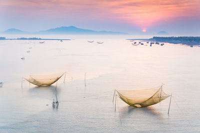 Fishing nets on lake during sunset