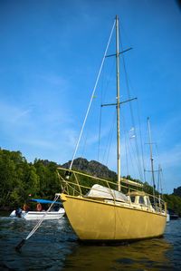 Sailboats moored on sea against sky