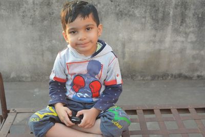 Portrait of cute boy sitting outdoors