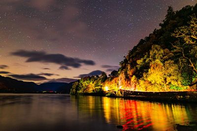 Scenic view of lake against sky at night