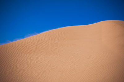 Scenic view of desert against clear blue sky