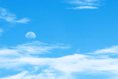 Low angle view of moon against blue sky