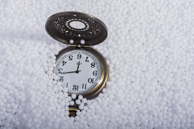 Close-up of pocket watch amidst white polystyrene