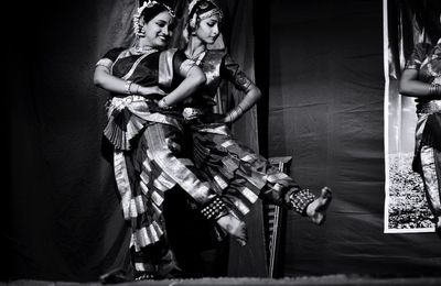 Smiling women performing traditional dance on stage