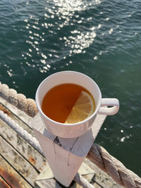 Cup of tea with a slice of lemon on the beach