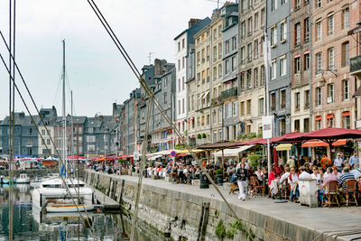People on street by buildings in city