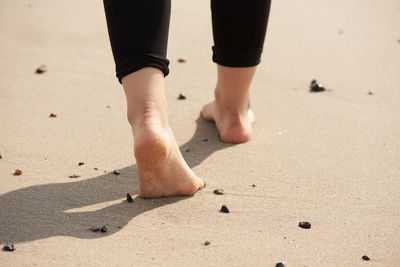 Low section of man standing on sand