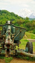 Abandoned vehicle on field against sky