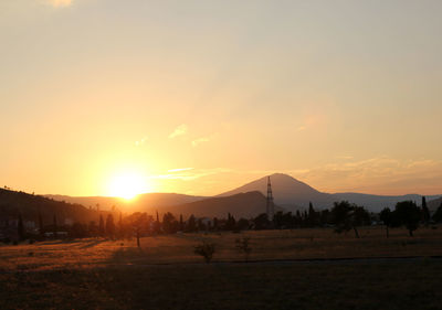 Scenic view of field against sky during sunset