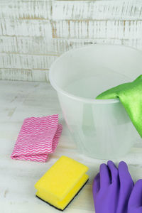 Close-up of gloves and cleaning equipment with bucket on floor