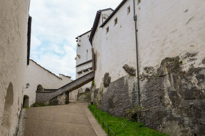 Low angle view of alley amidst buildings against sky