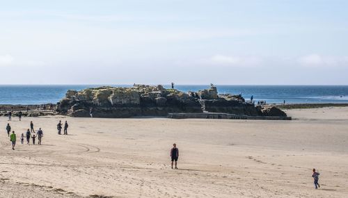 People on beach against sky